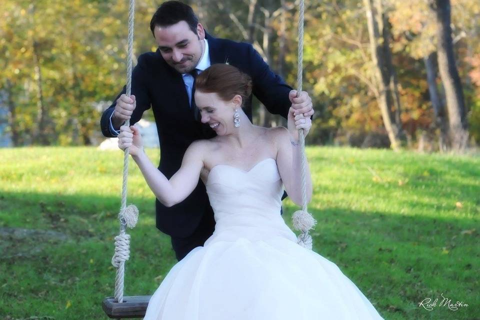 Groom pushing his bride on the swing