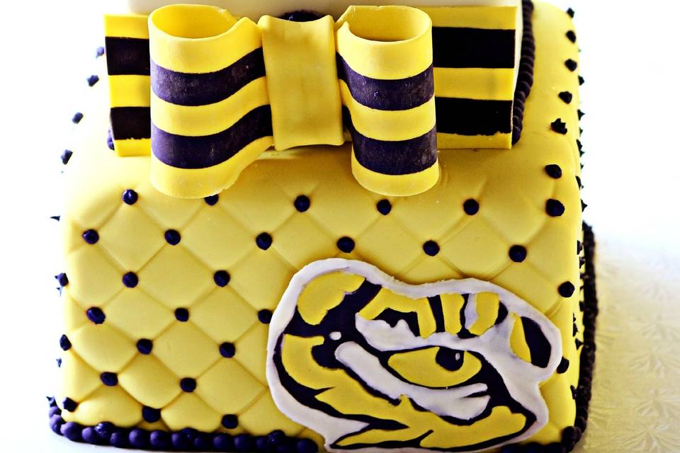 LSU Groom's Cake. 2 tiers with quilting, striped ribbon, gift bow topper, and fondant tiger eye.