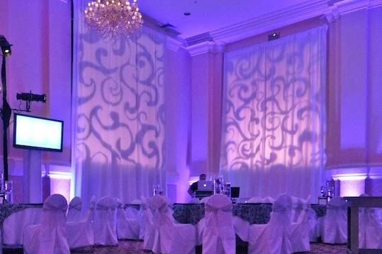 Lots of gobos!  What to do if you don't want to look out the windows onto the parking?  Drape them and lets us use them as a canvas to paint on!  Add some golden bubbles to the dance floor, ample architectural uplighting, and you have a stunning reception space!