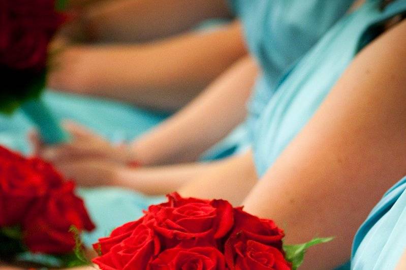 Red roses against pool colored dresses.