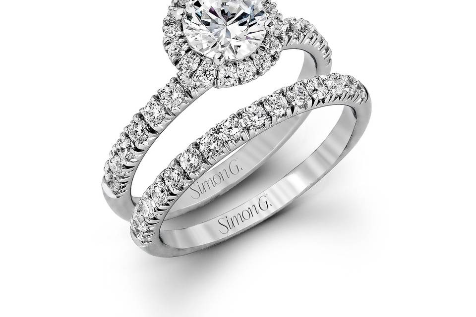 Style MR1811 <br> The classic halo design of this white gold engagement ring and wedding band are elevated by .80 ctw of shimmering round cut white diamonds