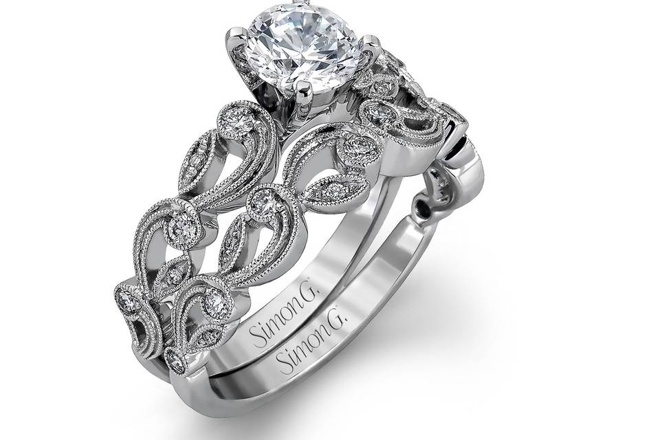 Style TR473 <br> This delicate floral inspired white gold engagement ring and wedding band set is accentuated with .28 ctw shimmering round cut white diamonds.