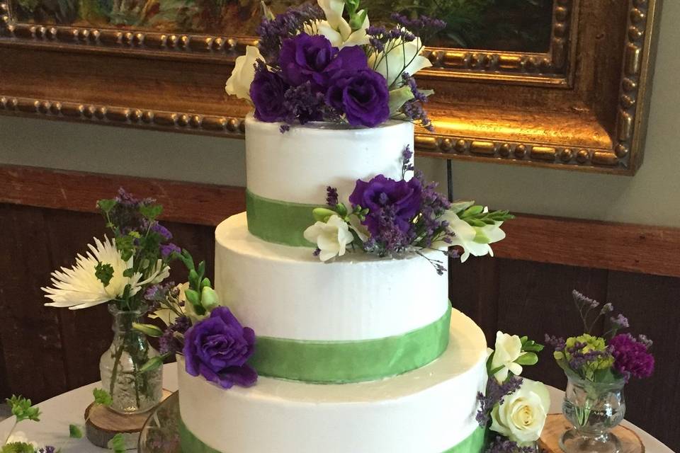 White cake with green ribbon band decorations