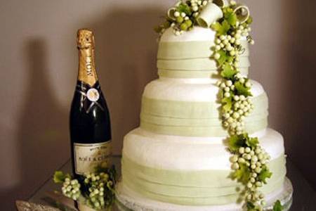 White cake with black ribbon bands and pink flowers