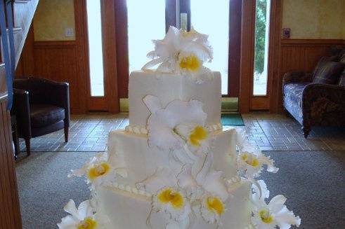 White cake with yellow flower decorations