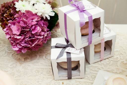 Cupcake favor boxes with tags and ribbons.