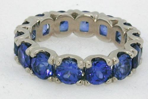 Tradeshop Eternity band, shown with tanzanite color blue sapphires.  Available for all shapes, in all metals and sizes.  We customize the band for your needs.