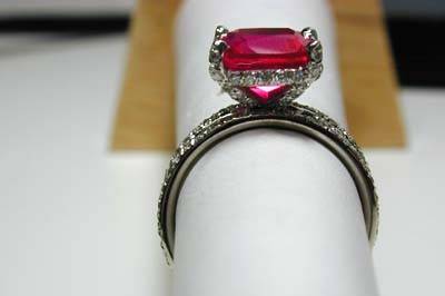 9x9 mm cushion cut ruby in custom pave halo ring with two flanking flush sit pave bands.  Diamonds on all prongs and cross bar.  Custom to your stone and taste.