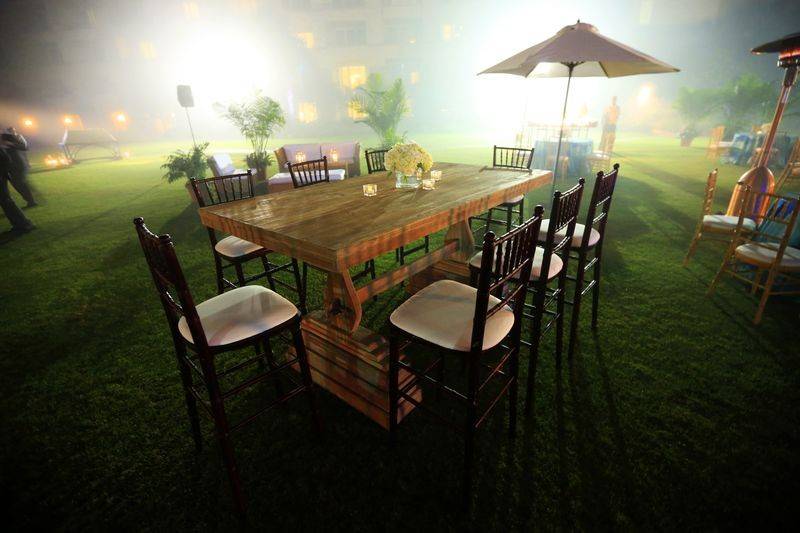 Seat your guests at a wooden trestle high top table for your garden wedding