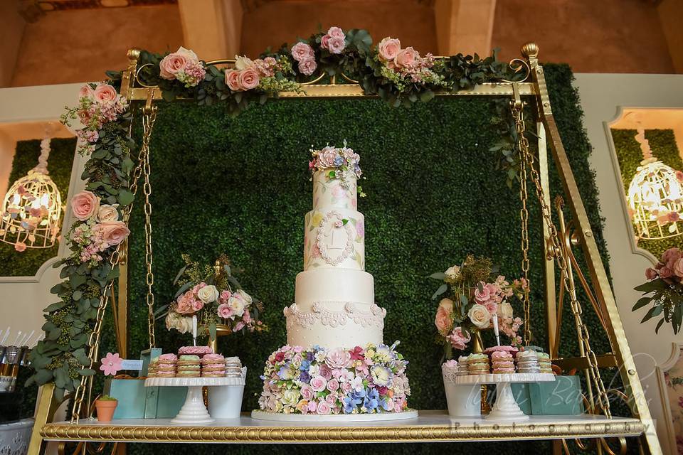 Swing cake table, hedge backdrop, Sienna backdrop panels with chandeliers