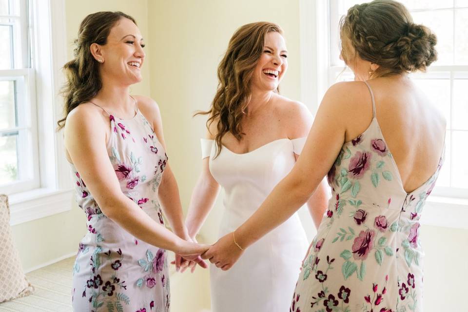 Bride laughs with sisters