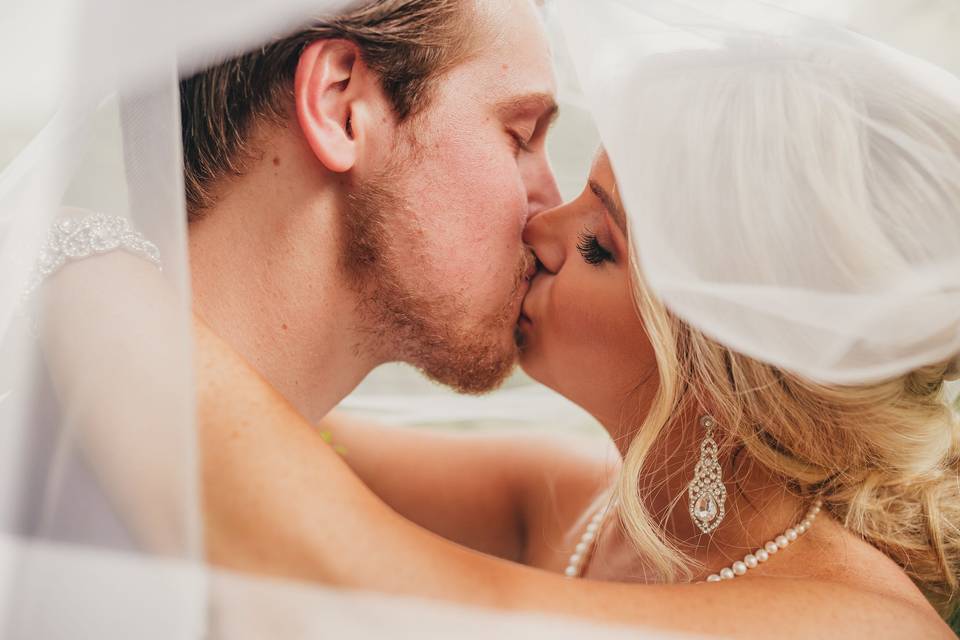 Bride and groom under veil