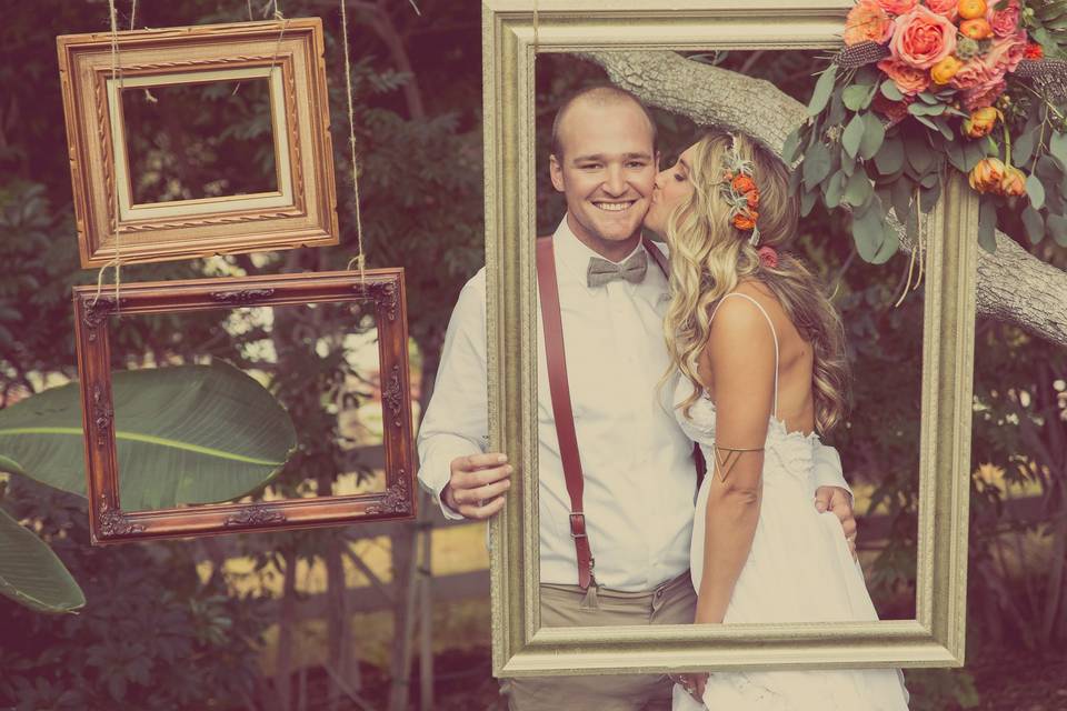 Guests were invited to take their photos behind these hanging frames in the courtyard during cocktail hour. We had some disposable cameras available, and we assumed many would have their own cameras and camera phones. The vintage frames were a hit and we added floral touches to make them pop even more.