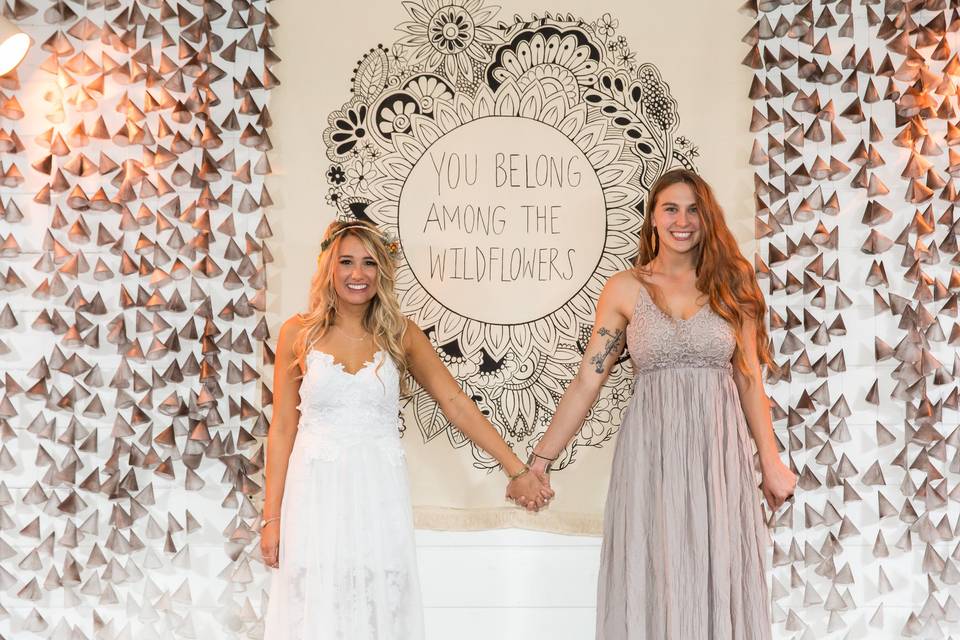 Custom backdrop inspired by one of the bride's favorite quotes. Decorated with hanging accents and placed behind the dance floor.