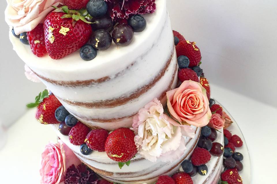 Naked cake with flower and berry decorations