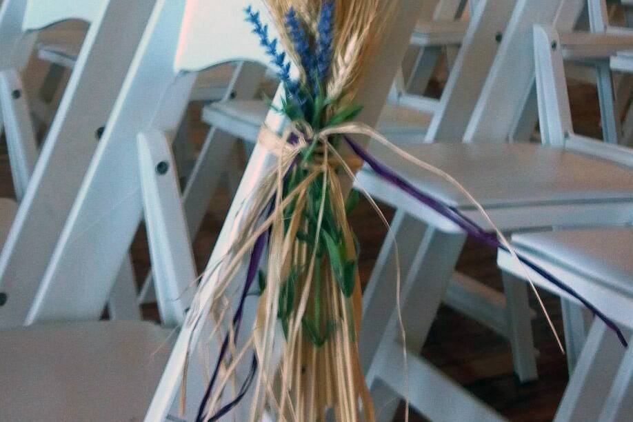 Wheat and lavender ceremony chair accents designed by mother of the bride