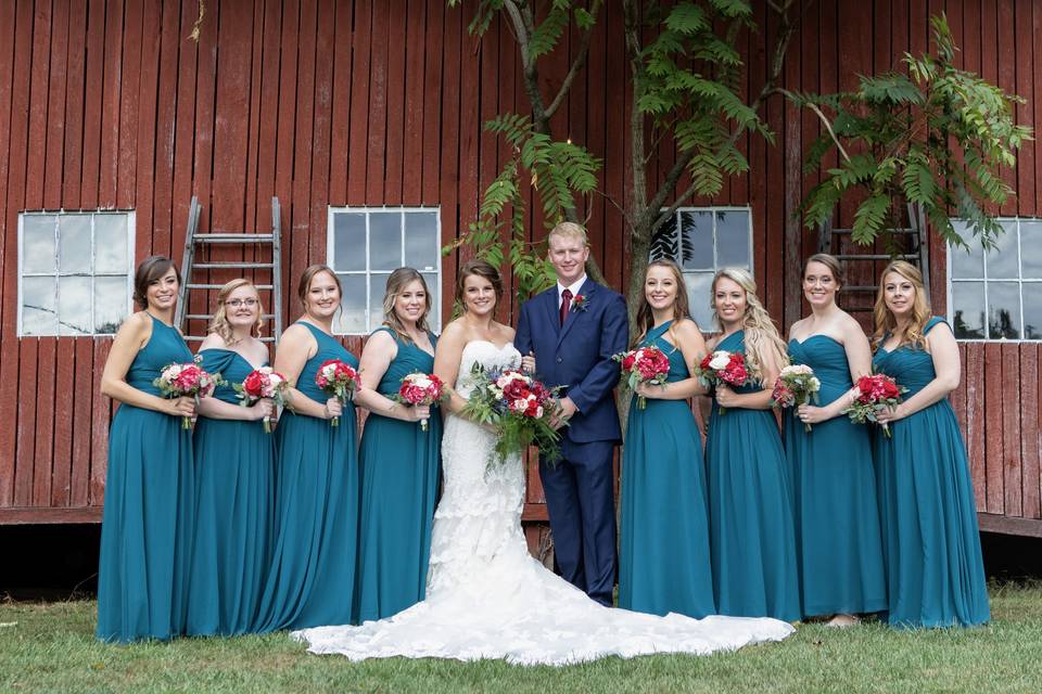 With wedding party by a barn