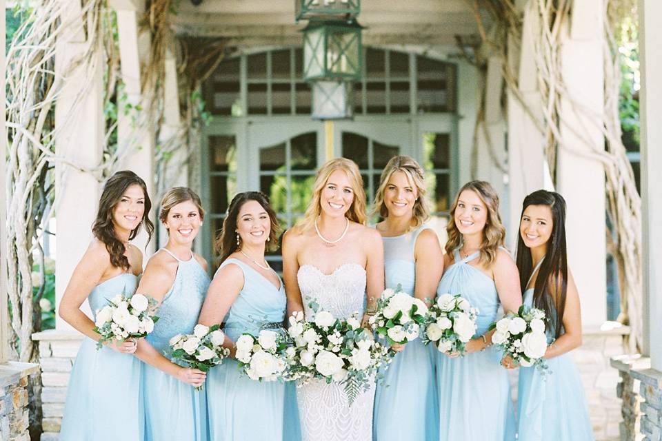 A happy bridal party at the clubhouse entrance