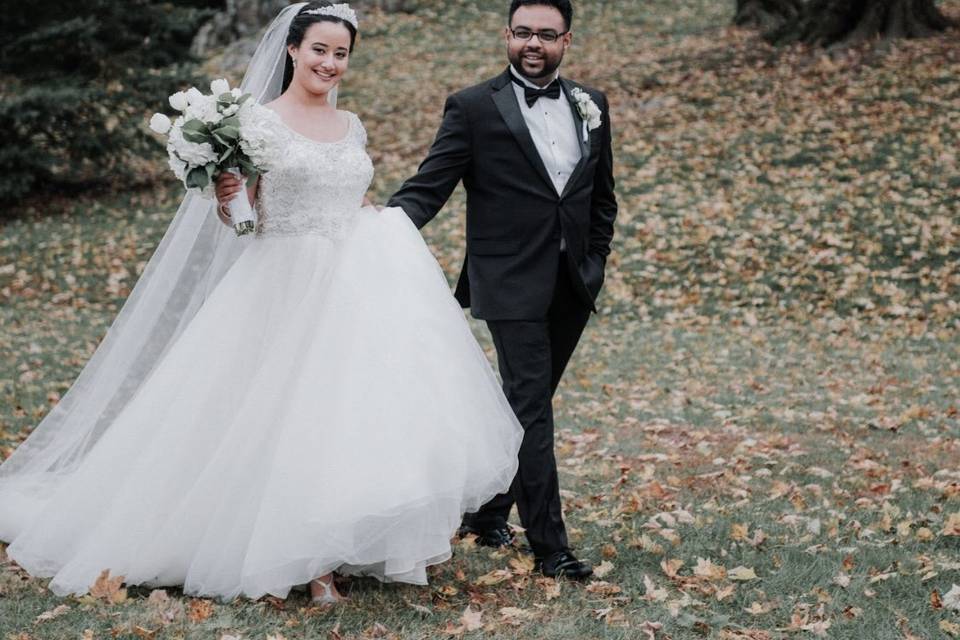 Newlyweds walking through the leaves