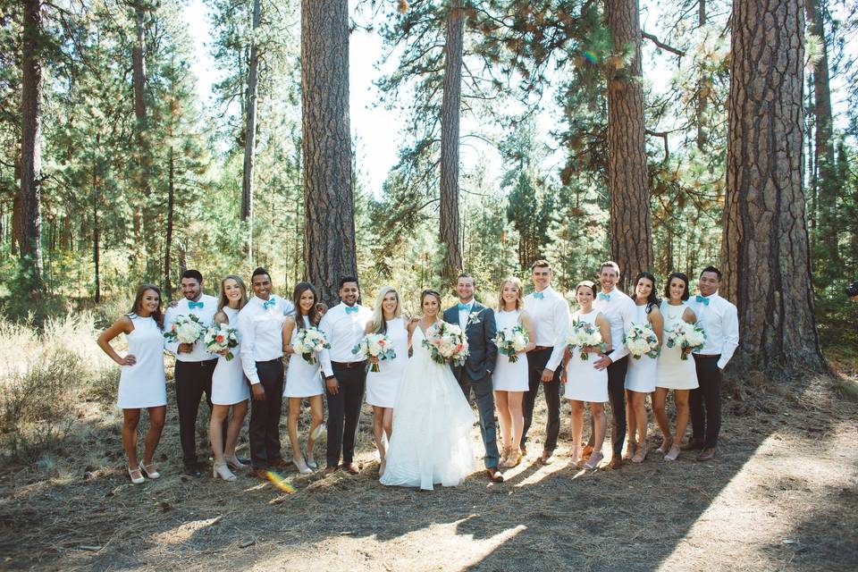 Newlyweds with wedding attendants in white