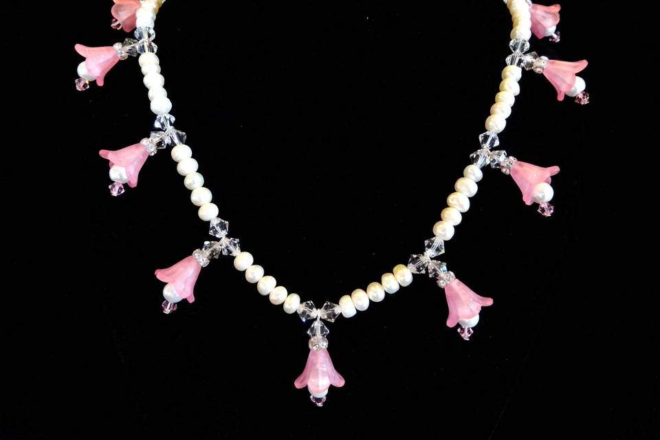 Very pretty pink flower and white cultured pearl necklace.
Unique and elegant!