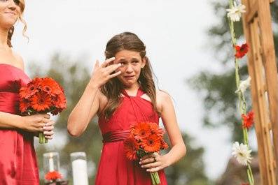 an adorable moment with the bride's younger sister drying tears of joy as the bride walks down the aisle.