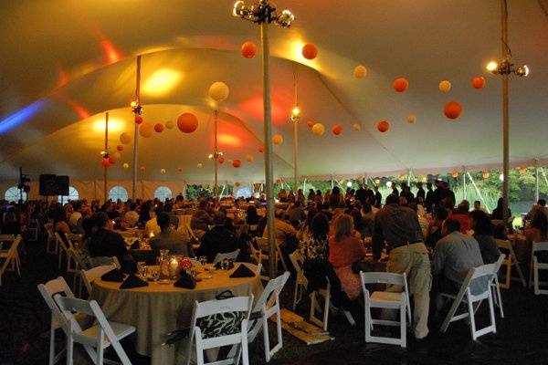 inside of a 60 wide twin peak tent with lights, chairs, tables, dance floor.