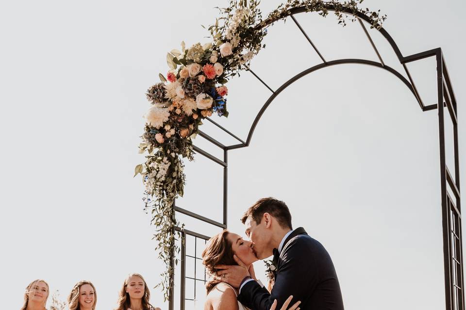 Newlyweds kiss under the arch