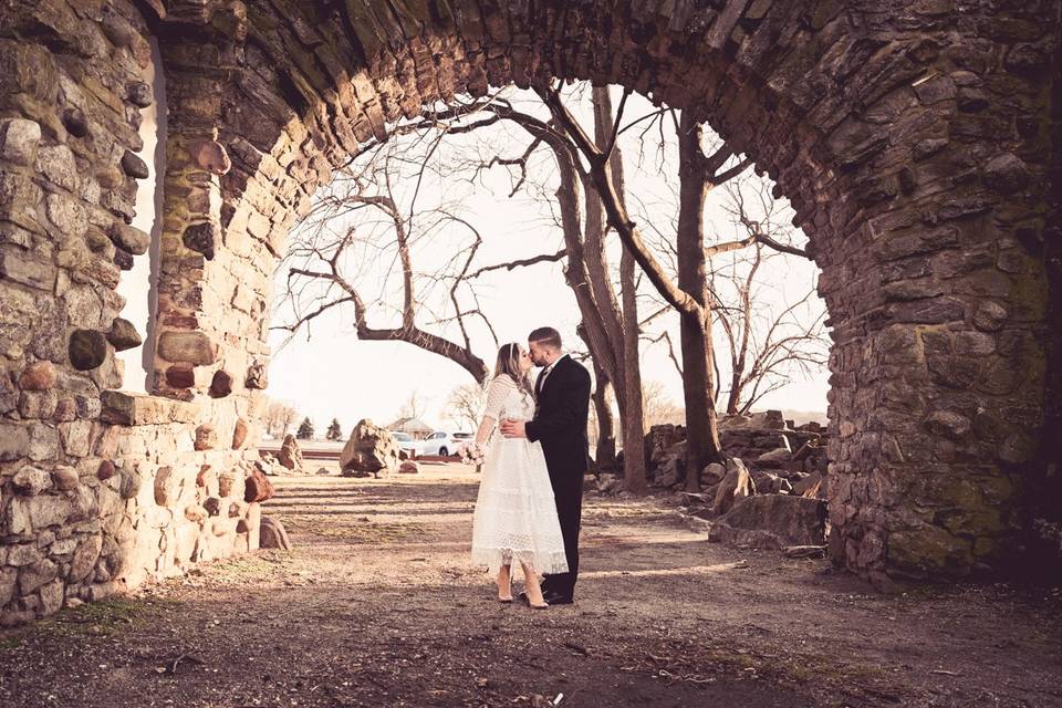 Kissing under a stone arch