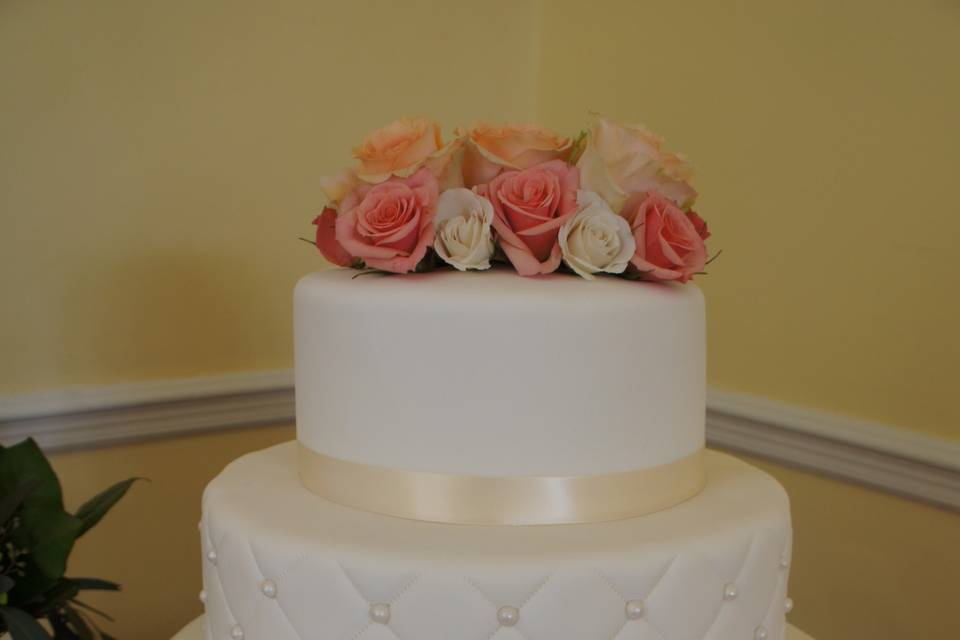 All white wedding cake with flowers on top