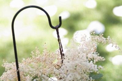 Delicate summer flowers line the aisle for a June bride.