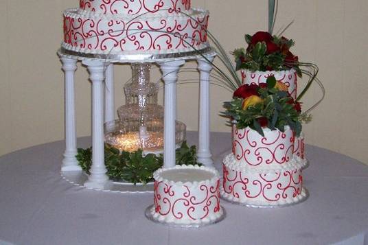 This creation is frosted in white buttercream with red c-scrolls.