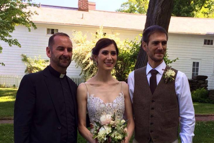 Happy newlyweds and officiant