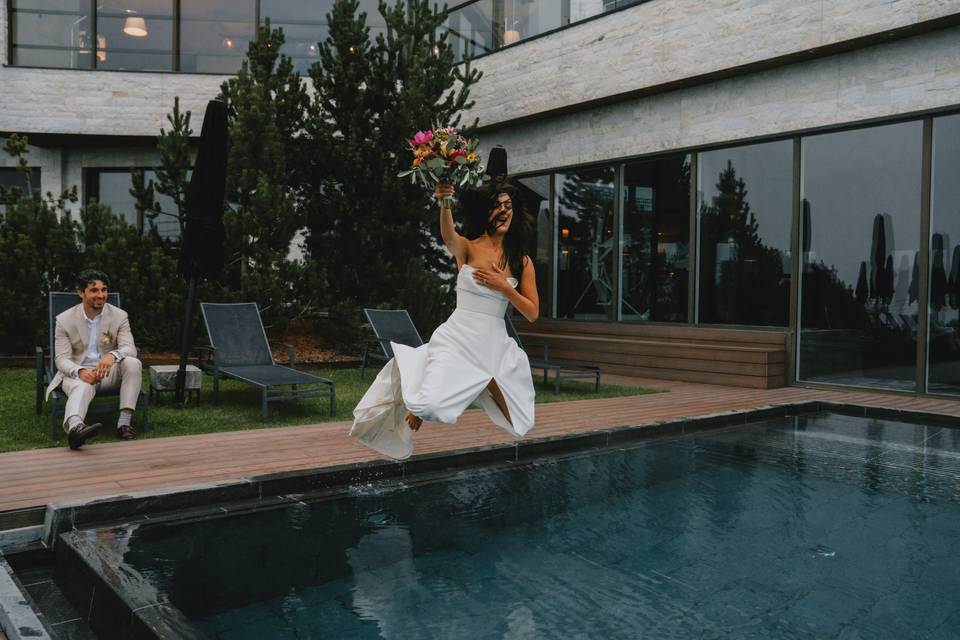 Bride jumping in the pool