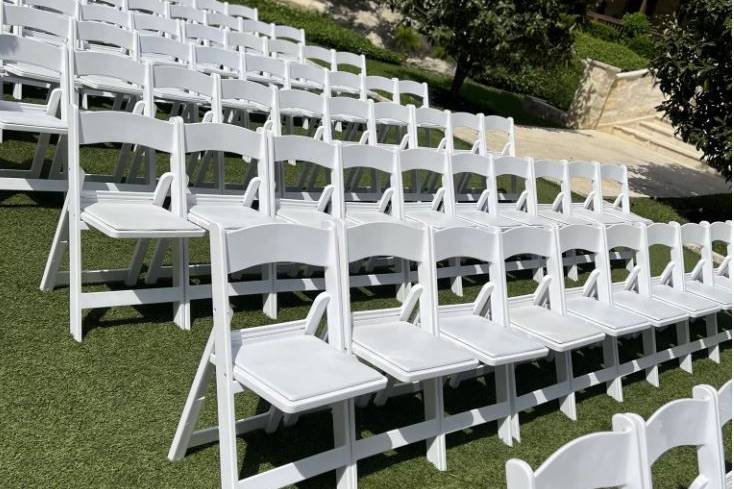 White fold-up chairs for outdoor ceremonies