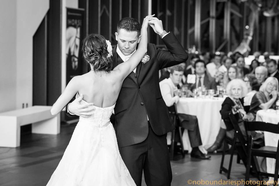 The couple embraces during their first dance as their guests enjoy the performance.