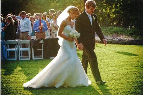 Groom and bride walking in the grass