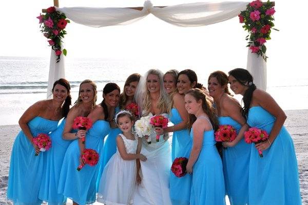 Bride, bridesmaids, and flower girl at the beach