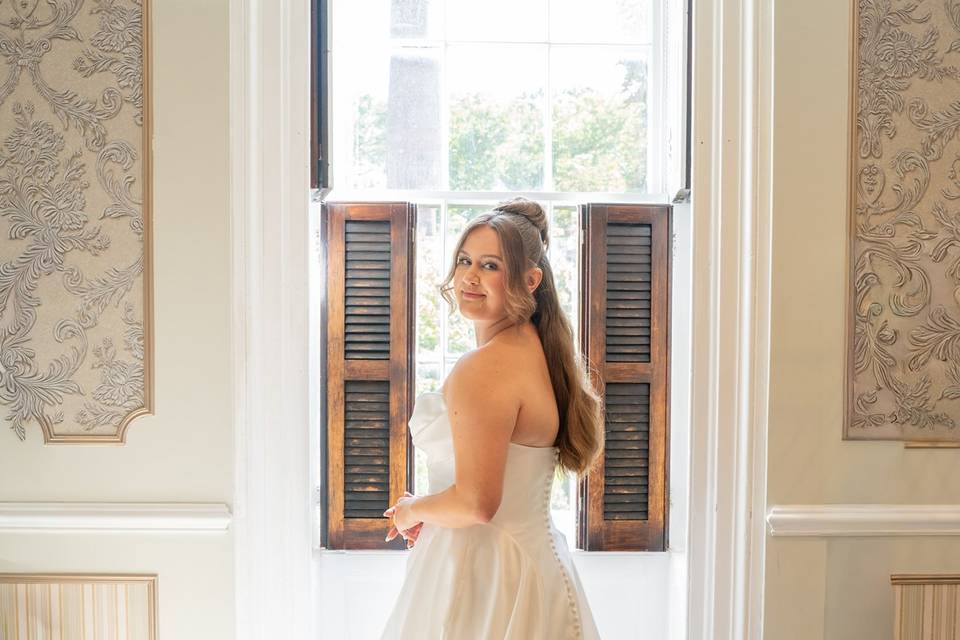 Bride posing by open window