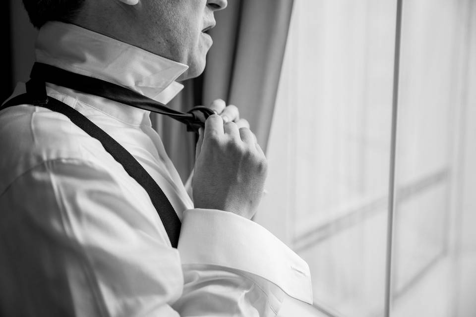 Groom tying bow tie
