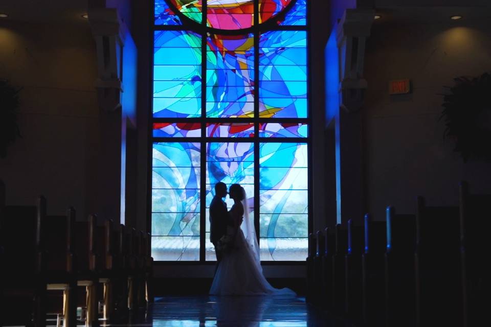 Couple standing before a stained-glass window