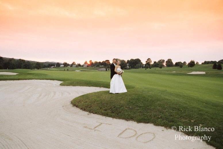 A bride and groom enjoy the sunset and landscape