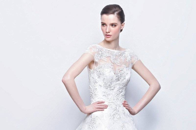 ISLA
This form-fitting gown has a high illusion neckline covered in white floral appliqués, and adorned illusion back .