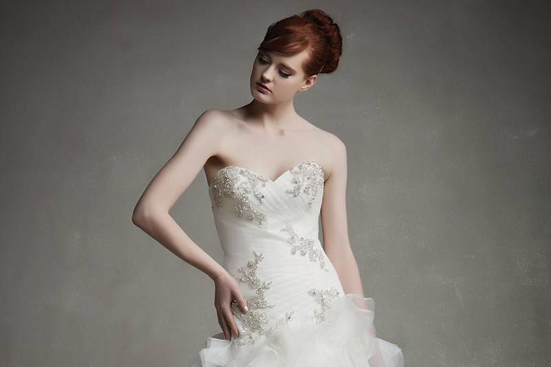 Enzoani Jacqueline
<br>The picture of sophistication and romance, with a sweetheart neckline, dropped waistline, and gorgeous beaded appliqués on the ruched tulle bodice with ruffled modified A-line skirt. Polished with an invisible zipper back.