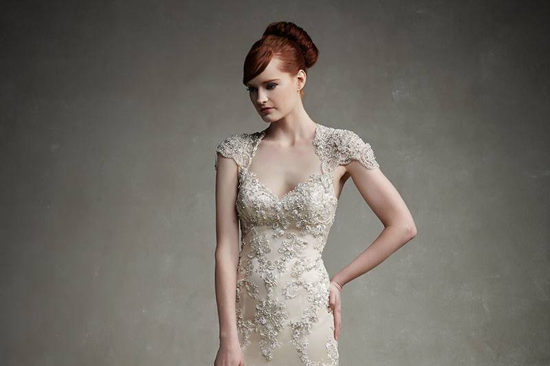 Enoani Jaime
<br>Classic elegance is embodied in this floor-length gown with beautiful beaded cap sleeves and beaded appliqués adorning a bodice and skirt of lace over tulle and charmeuse. The romantic look is finished with a delicate beaded floral lace hem and invisible zipper back.