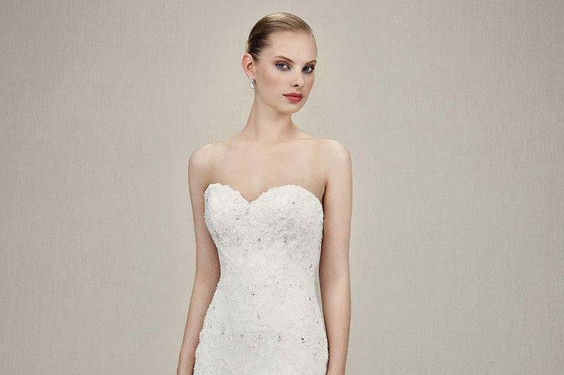 Style Kylee <br> Full-length ball gown of beaded embroidered lace, Alencon lace, and Chantilly lace. Adorned with silver beaded appliqués on sweetheart neckline bust. Tiered tulle layers cascade down from low V-back.