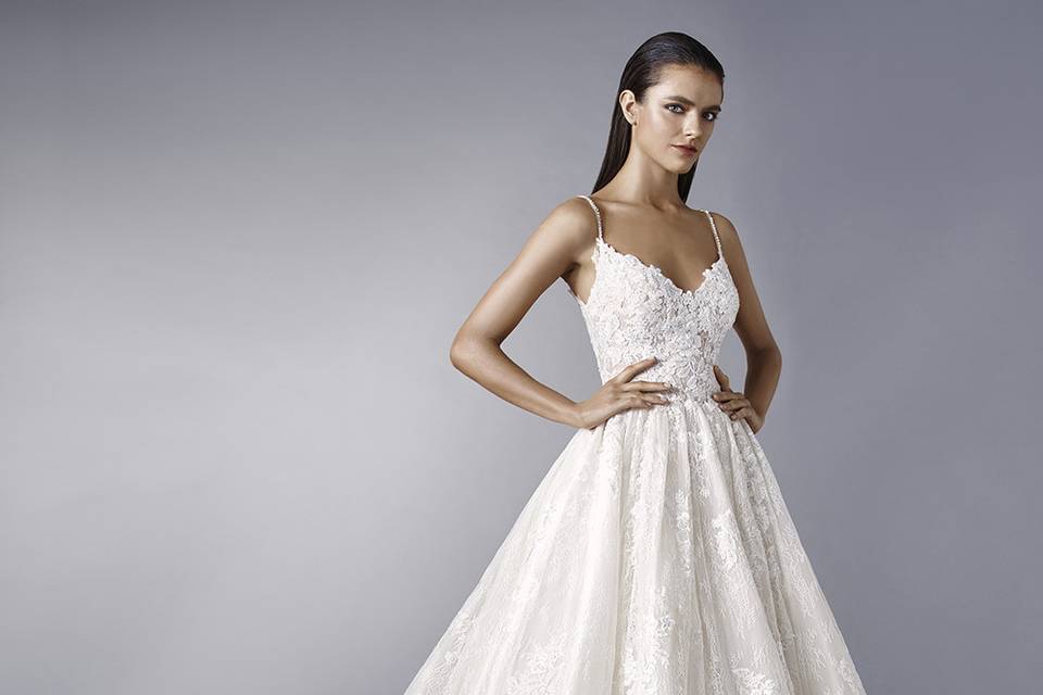 Enzoani	Maddie		Make a dramatic entrance with this dreamy ball gown featuring romantic overlace. The V-neckline is supported by rhinestone straps for extra sparkle. Finished with crystal buttons.