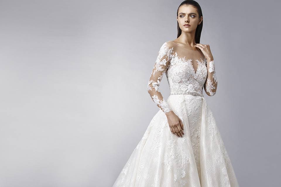 Enzoani	Maddie		Make a dramatic entrance with this dreamy ball gown featuring romantic overlace. The V-neckline is supported by rhinestone straps for extra sparkle. Finished with crystal buttons.