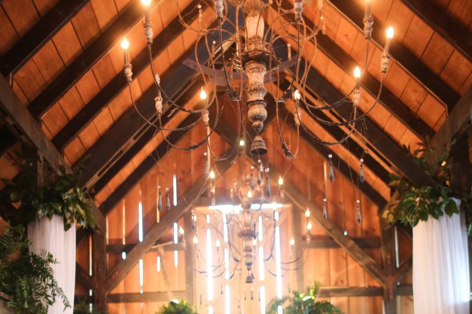 Our Dutch Style Barn features rough sawn beams, reclaimed heart pine flooring, and vintage chandeliers.
