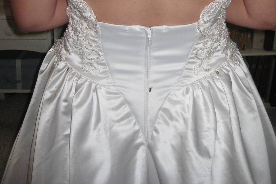The zipper and beadwork was removed. Darts put in the sides and new back inset with zipper sew in.